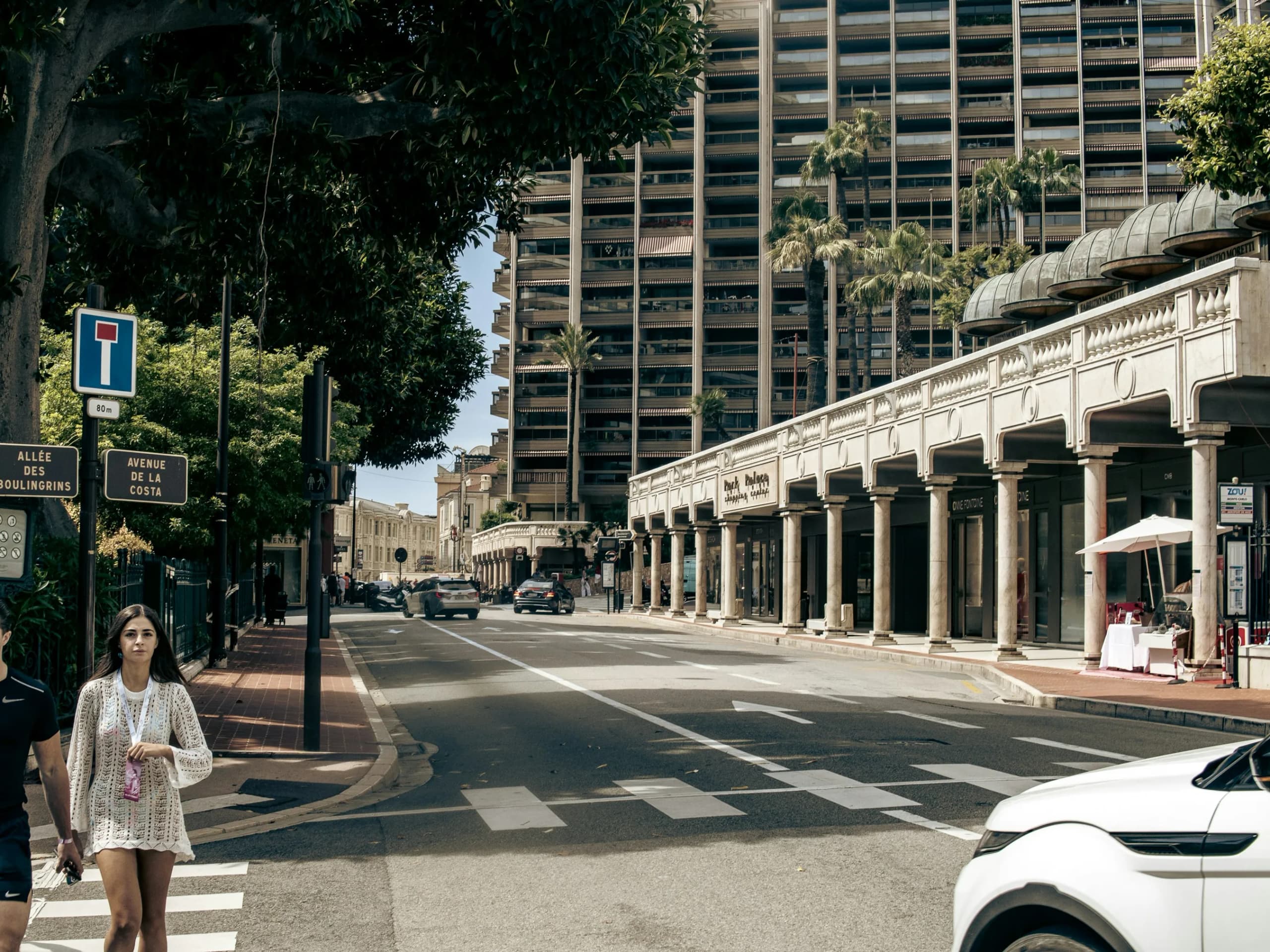 An everyday Monaco street, colonnade and apartment blocks in the midday sun.